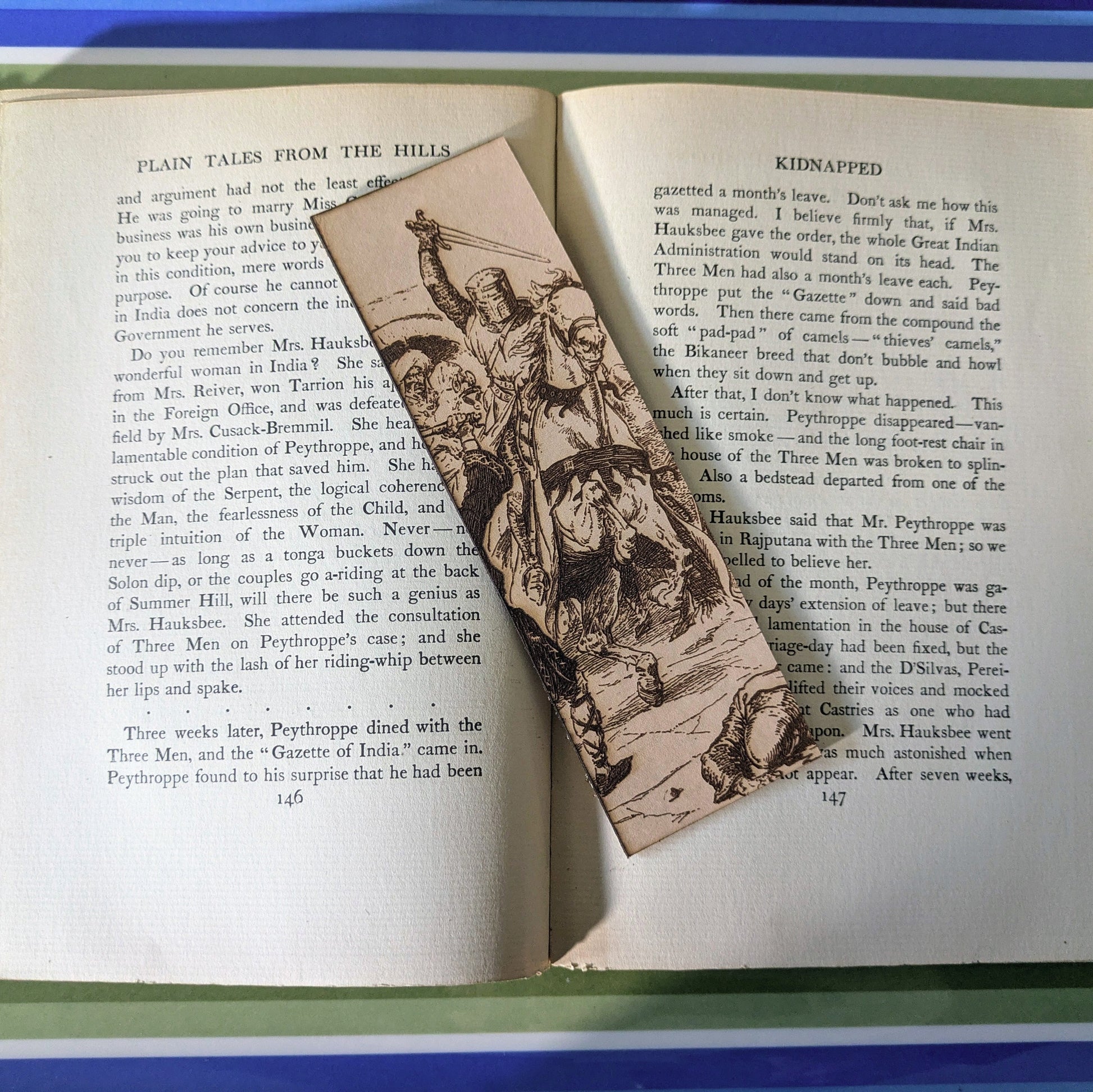 A knight on horseback bookmark on the pages of an open book. Knight on Horseback Charging - Leather Bookmark Bookmarks Raven King Crafts