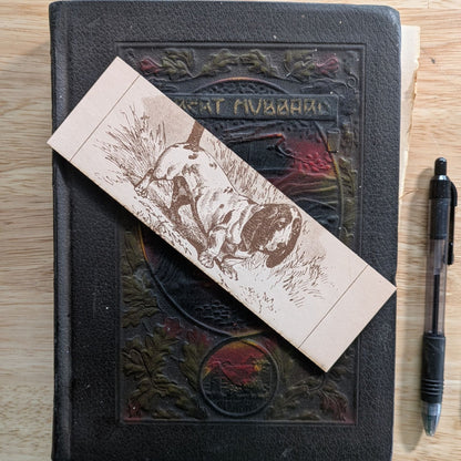 A rectangular leather bookmark with the historical art of a basset hound dog engraved on it. Leather Basset Hound Bookmark Bookmarks Raven King Crafts Leather Basset Hound Bookmark Bookmarks Raven King Crafts