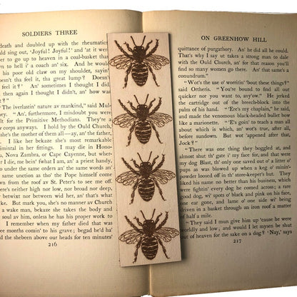 A photograph of a leather bookmark resting on the open pages of an antique book.