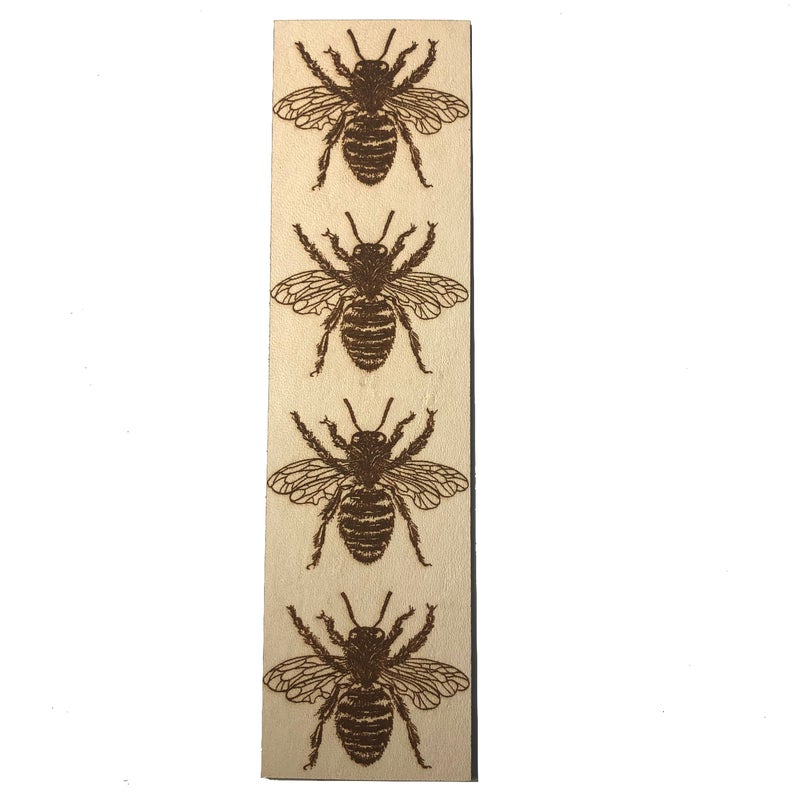 The photograph shows the rectangular leather bookmark with 4 bees engraved (burned onto) it.