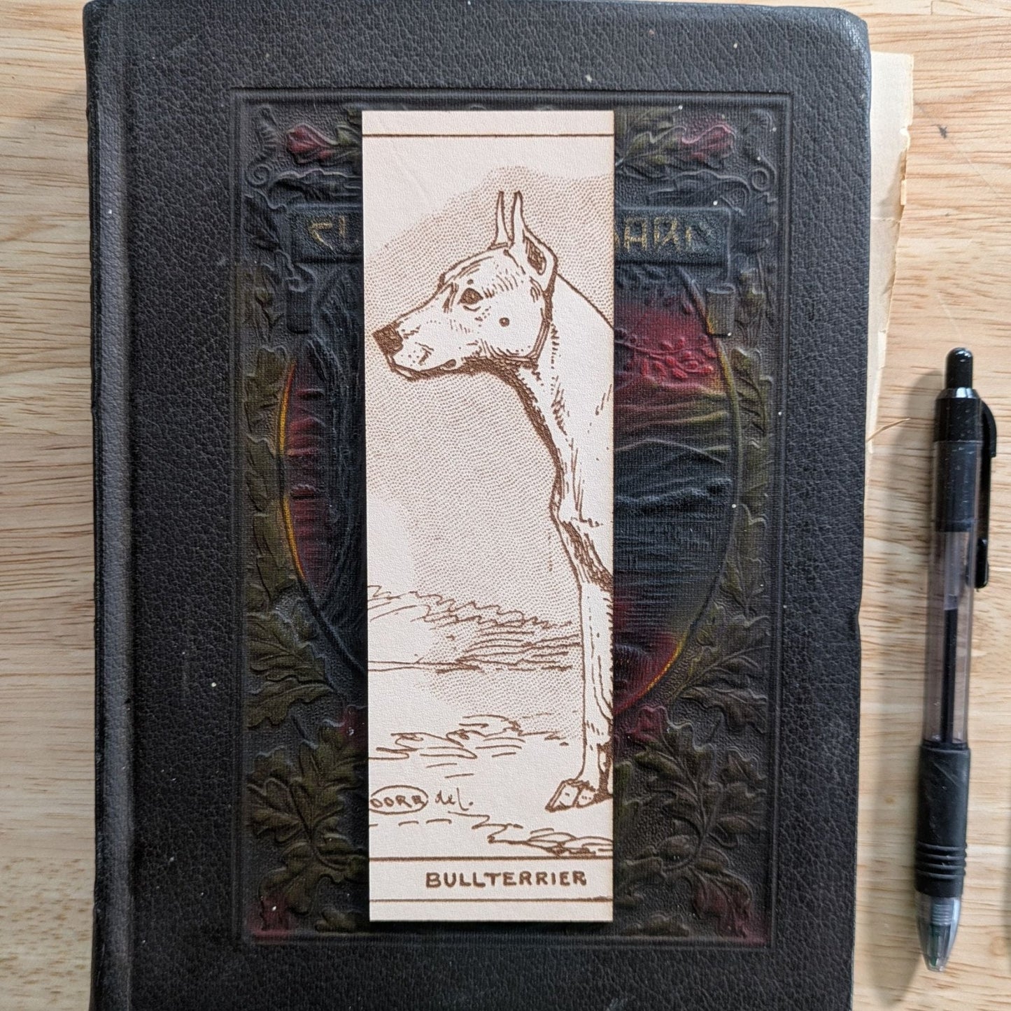 A rectangular leather bookmark with the historical art of a bull terrier dog engraved on it. Leather Bull Terrier Dog Bookmark Bookmarks Raven King Crafts Leather Bull Terrier Dog Bookmark Bookmarks Raven King Crafts