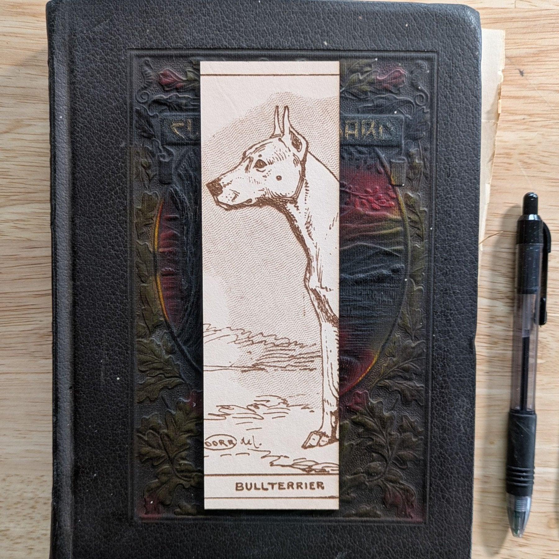A rectangular leather bookmark with the historical art of a bull terrier dog engraved on it. Leather Bull Terrier Dog Bookmark Bookmarks Raven King Crafts Leather Bull Terrier Dog Bookmark Bookmarks Raven King Crafts