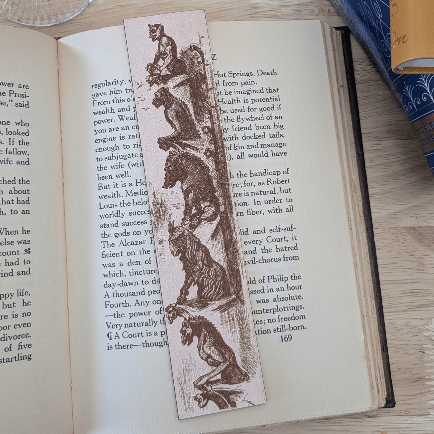 A photograph of a leather bookmark featuring the historical art of gargoyles.