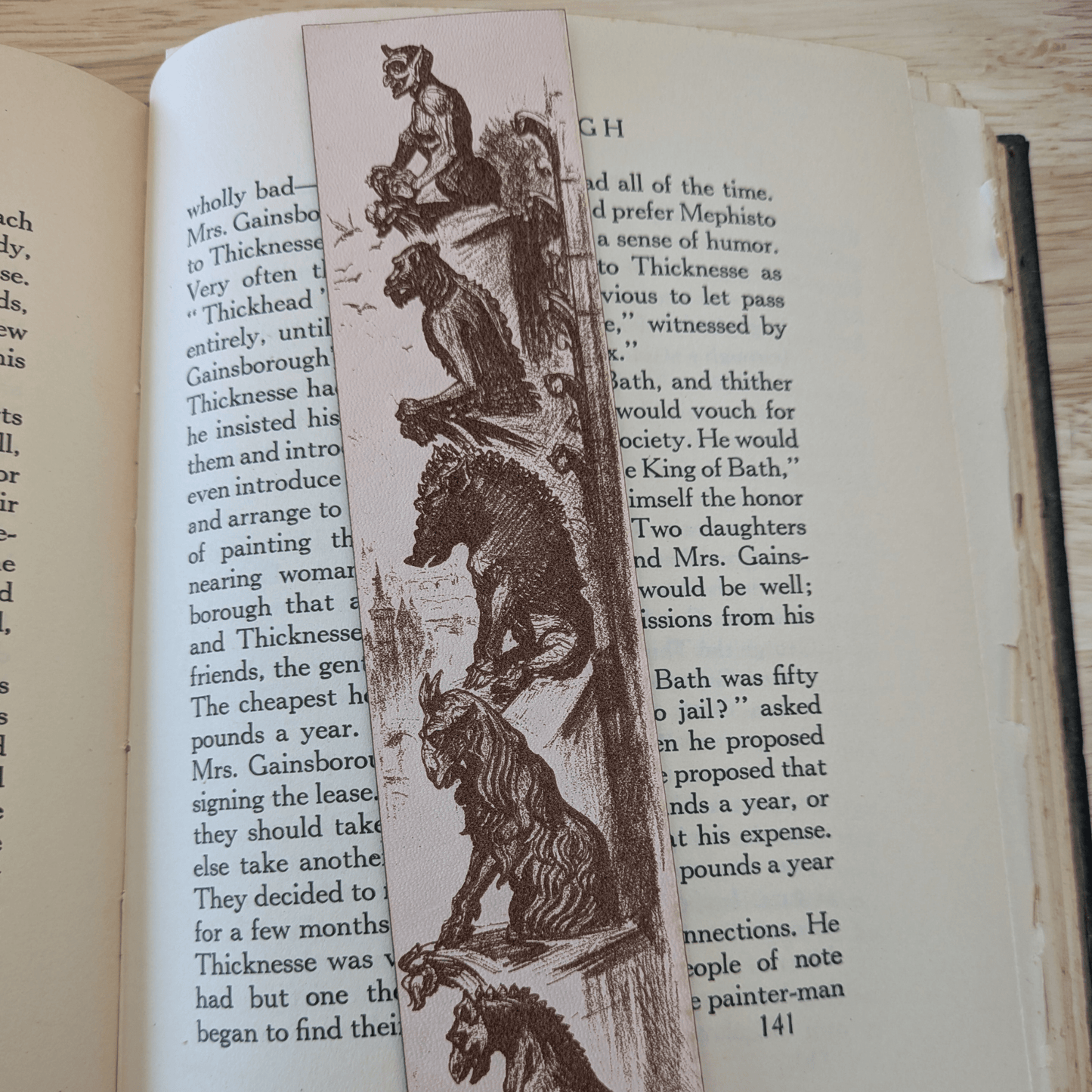 A leather bookmark engraved with the historical art of a collection of gargoyles. Leather Engraved Gargoyles Bookmark