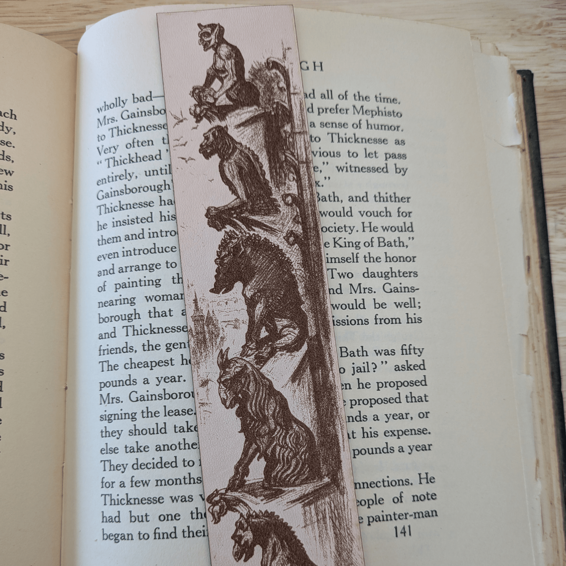 A leather bookmark engraved with the historical art of a collection of gargoyles. Leather Engraved Gargoyles Bookmark