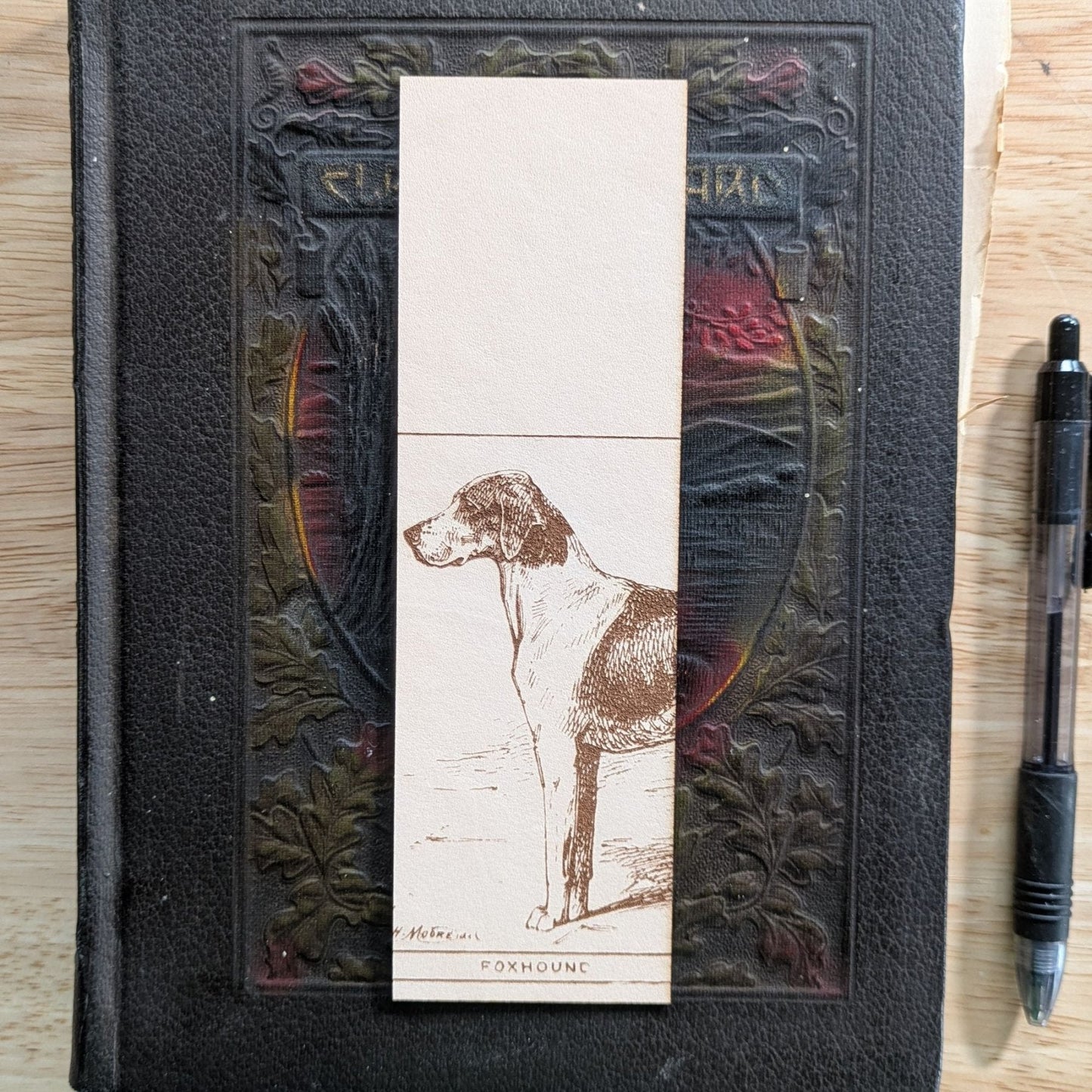 A rectangular leather bookmark with the historical art of a foxhound dog engraved on it. Leather Foxhound Bookmark Bookmarks Raven King Crafts Leather Foxhound Bookmark Bookmarks Raven King Crafts