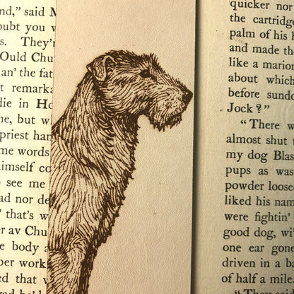 A closeup of the art of the irish wolfhound. This time the bookmark is sitting on the pages of an open book so text is visible behind it.