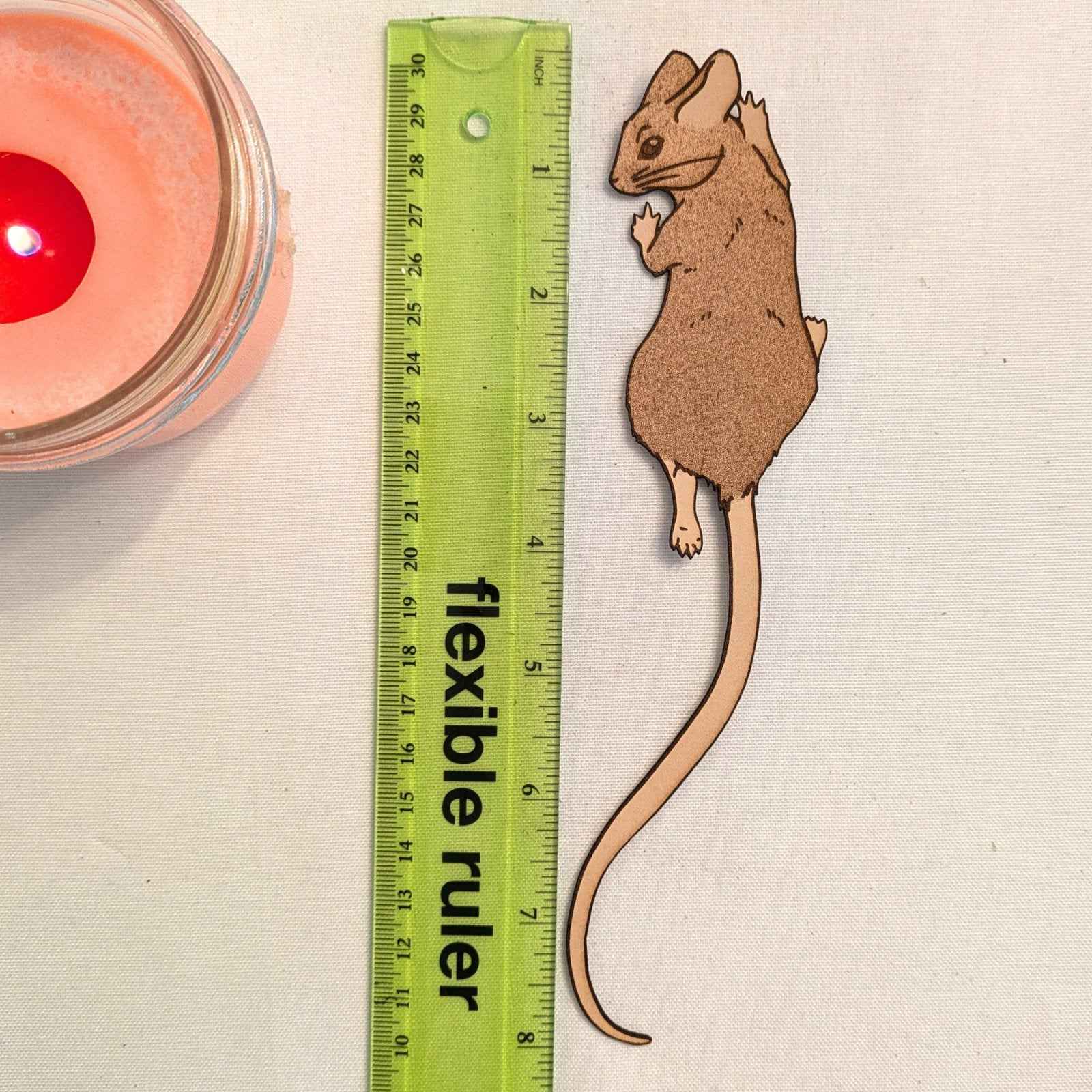 A photograph of exclusive climbing mouse leather bookmark next to a ruler for scale. Leather Mouse Bookmark - Cute Little Book Buddy Bookmarks Raven King Crafts