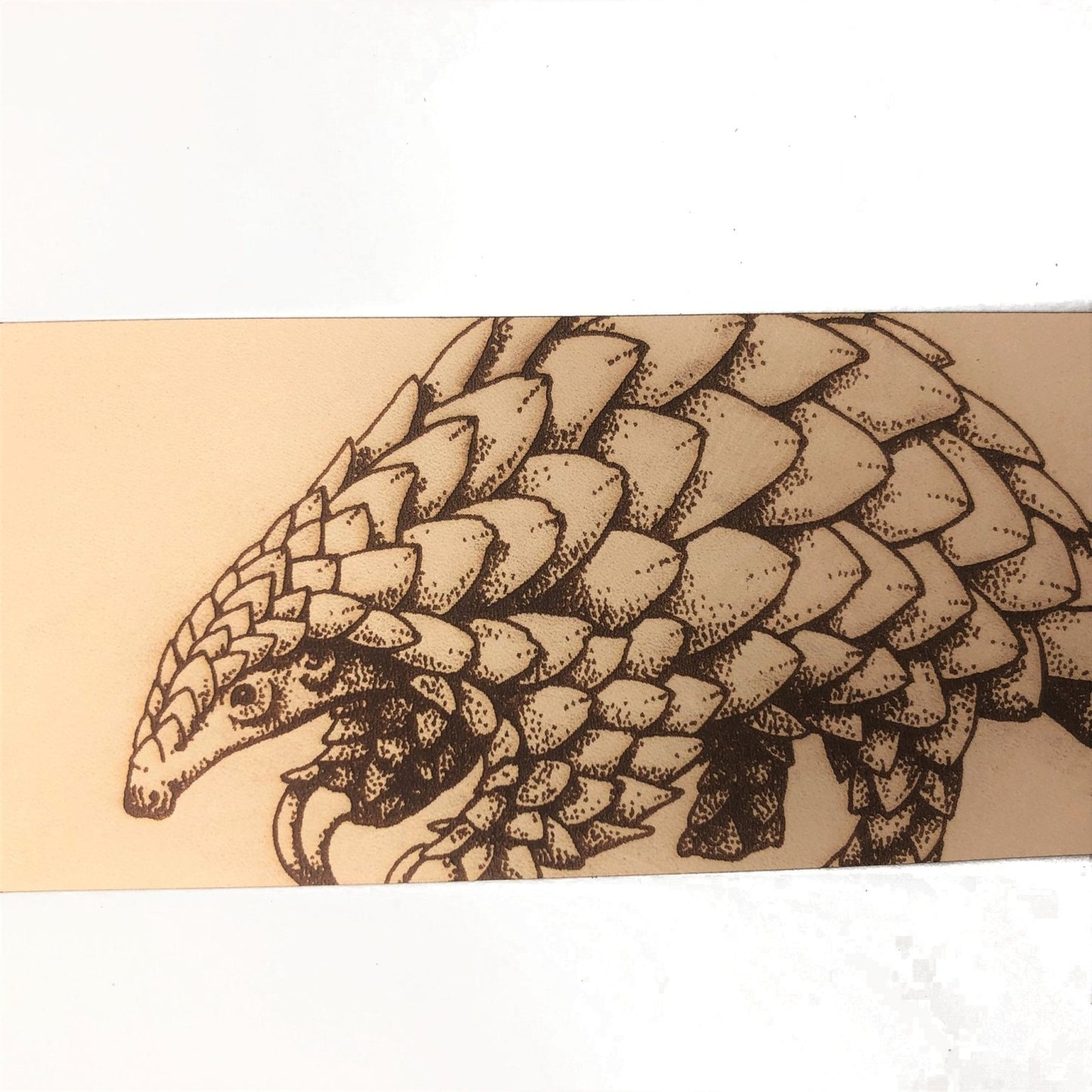 A close up of the pangolin bookmark.