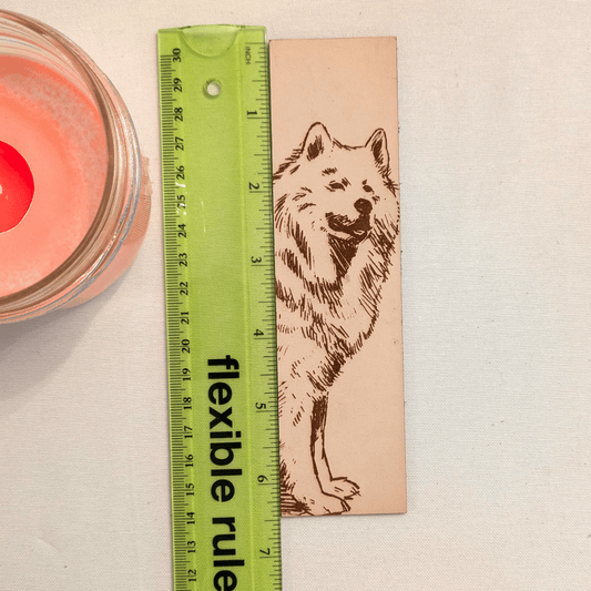 The leather Samoyed, dog bookmark next to a green ruler to show scale. Leather Samoyed Bookmark (working dog) Bookmarks Raven King Crafts Leather Samoyed Bookmark (working dog) Bookmarks Raven King Crafts