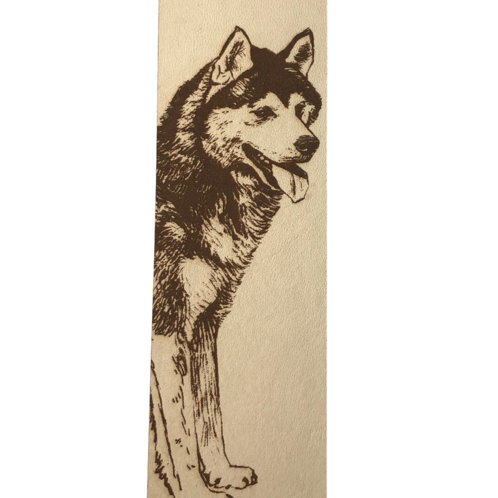 A close up of the Siberian husky bookmark. The grain of the leather is visible and the husky dog has it's tongue sticking out.