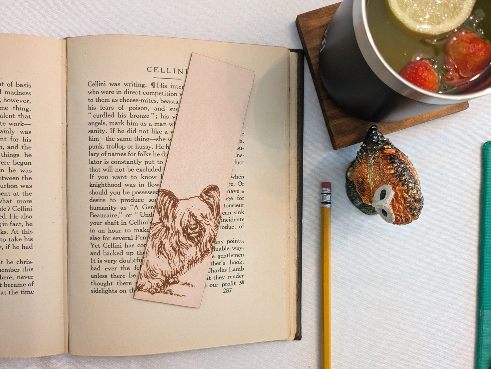 The leather skye terrier, dog bookmark resting on the pages of an open book. to the right of it is a pencil and a glass for scale. Leather Skye Terrier Bookmark (toy dog) Bookmarks Raven King Crafts Leather Skye Terrier Bookmark (toy dog) - Pick one or get both! Bookmarks Raven King Crafts