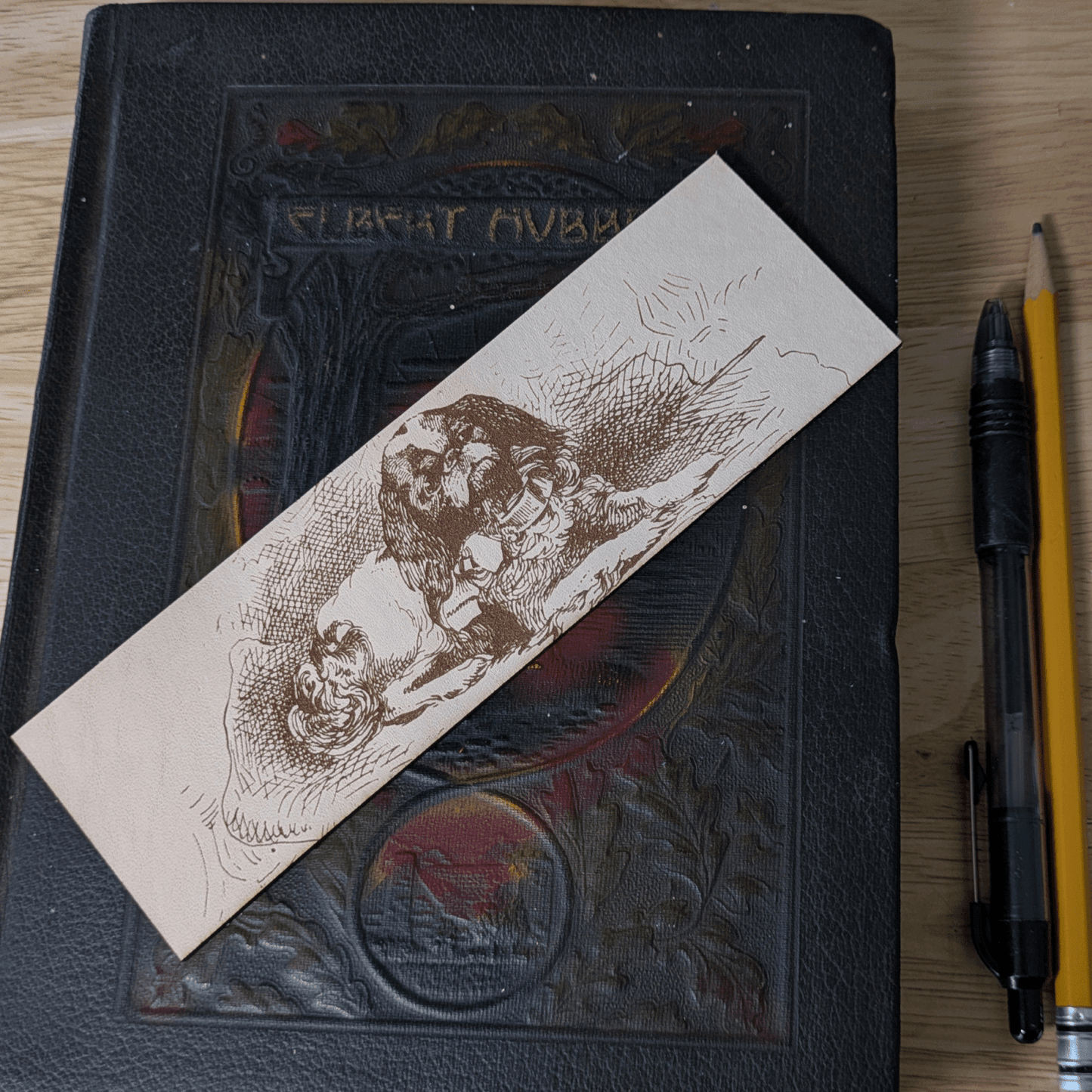 A rectangular leather bookmark with the historical art of a small spaniel dog engraved on it. Leather Spaniel Bookmark Bookmarks Raven King Crafts Leather Spaniel Bookmark Bookmarks Raven King Crafts