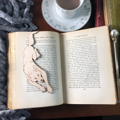 A larger picture of the wolf shaped bookmark resting on a book.