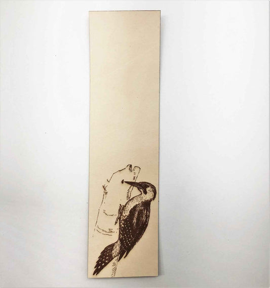 This leather bookmark is engraved with the historical art ofa woodpecker bird on it. Leather Woodpecker Bookmark Bookmarks Raven King Crafts