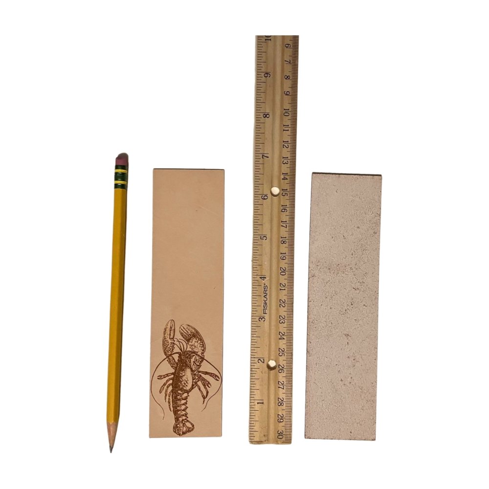 A photograph of the front of the leather bookmark and the back. The bookmarks are next to a ruler and a pencil for scale. Back photo shows the bookmark back is unfinished.