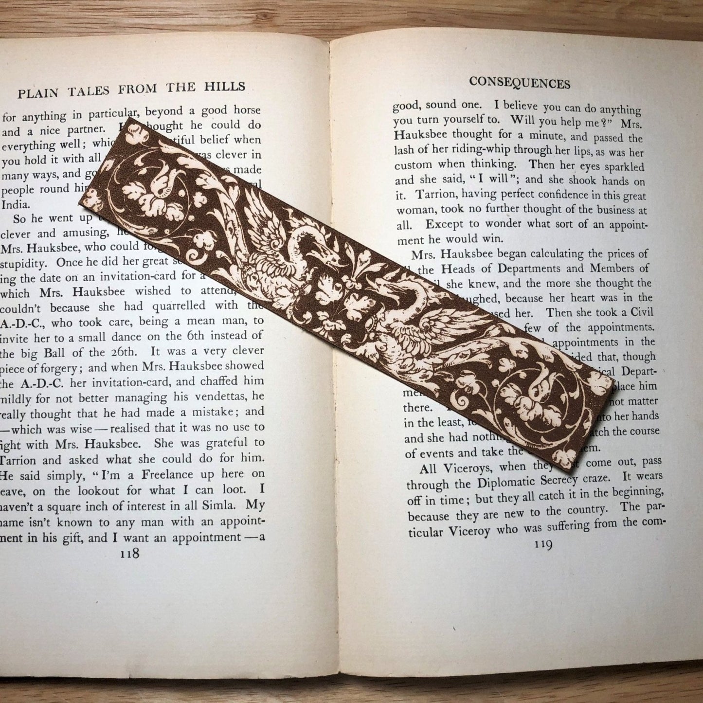 A leather bookmark with the antique art of 2 medieval swans on it.