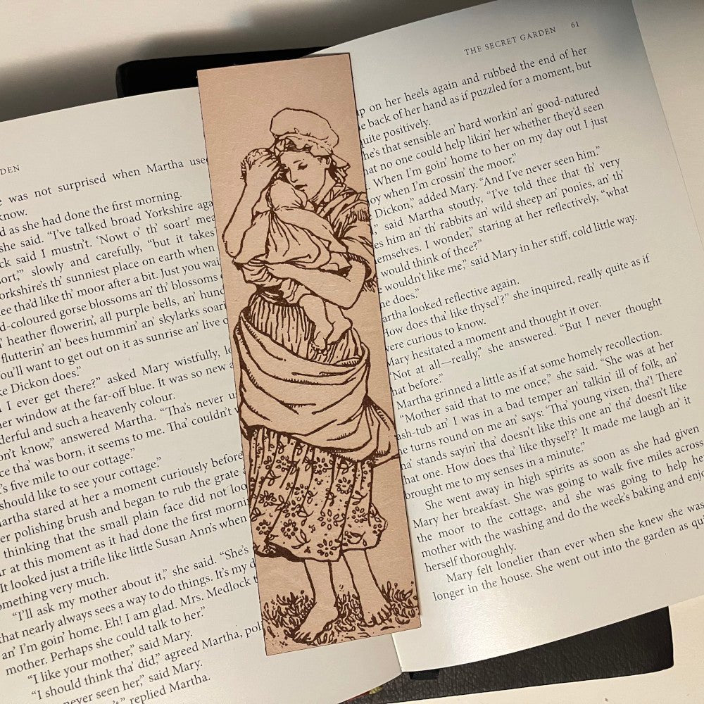 A bookmark with the art of a mother holding an infant.