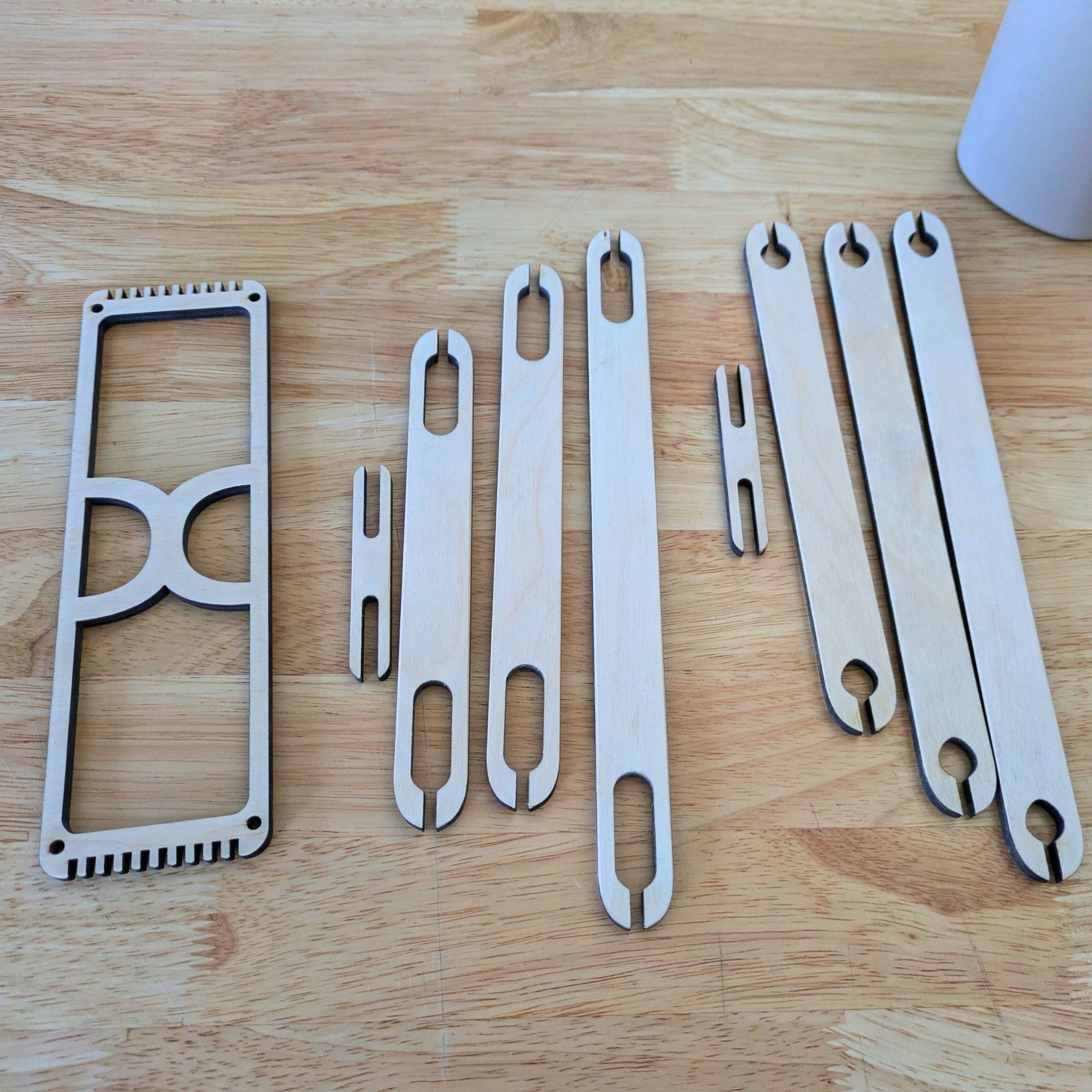 The bookmark loom next to the long shuttle sticks. 