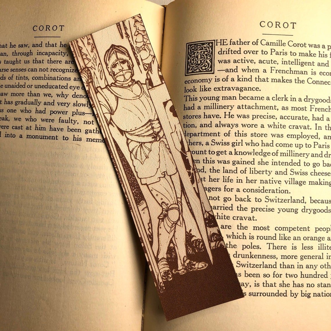 The photo shows a rectangular shaped leather bookmark with the art of a knight wearing full plate armor including a helmet.