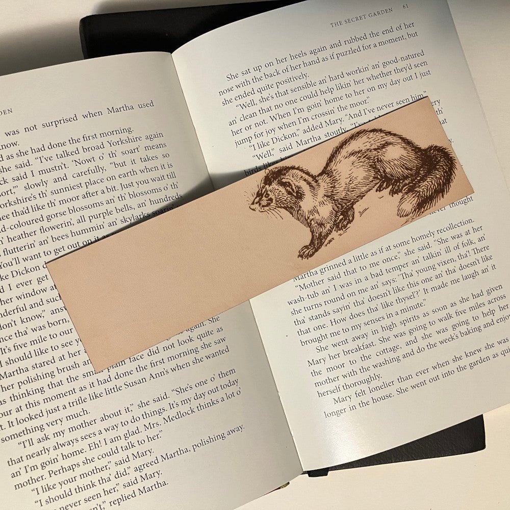 A rectangular leather bookmark with the art of a polecat engraved on it.