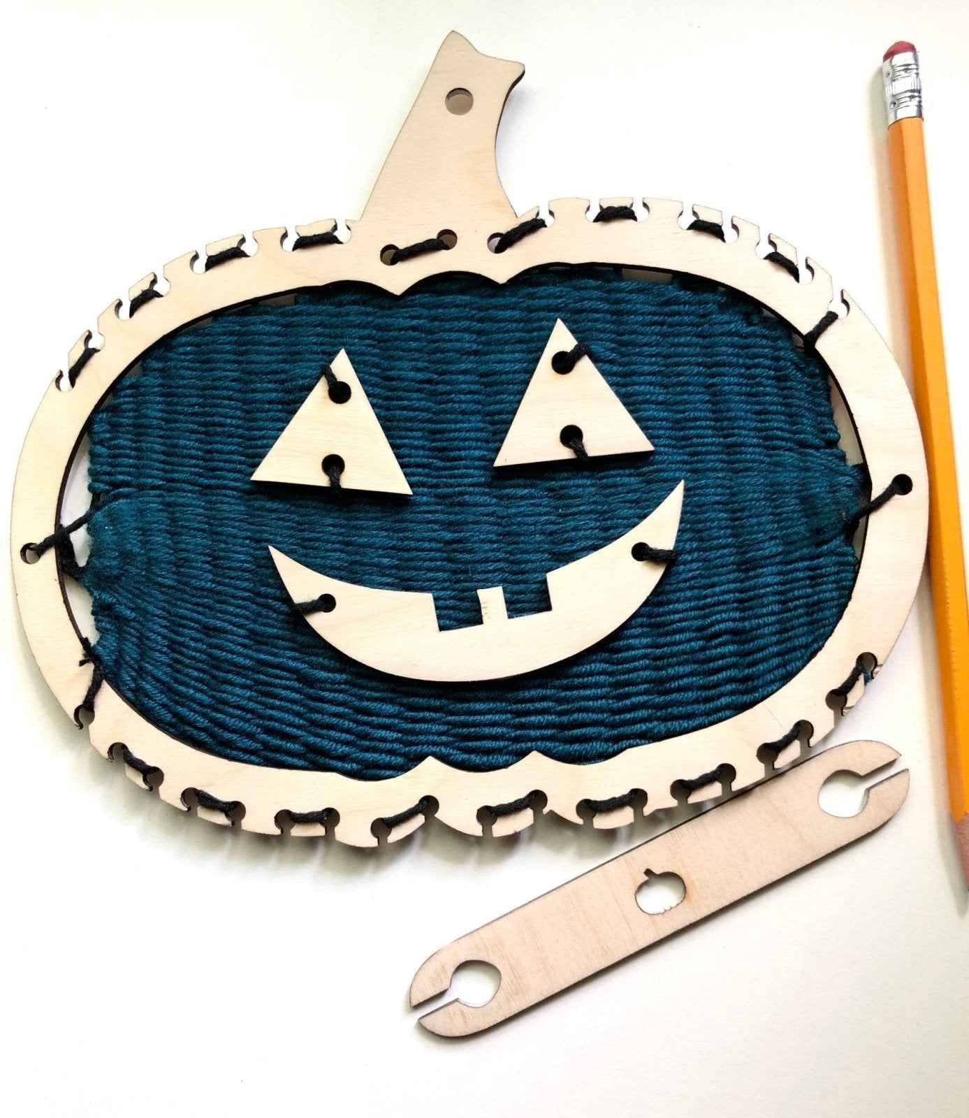 A picture of our fun Halloween themed look it, including pumpkin looms, jack-o-latern pieces, yarn and a shuttle. Pumpkin Themed Loom Craft Kit Art & Crafting Materials Raven King Crafts
