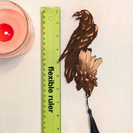 A photograph of exclusive raven on a crystal leather bookmark next to a ruler for scale. Raven Bookmark - Leather Bookmarks Raven King Crafts