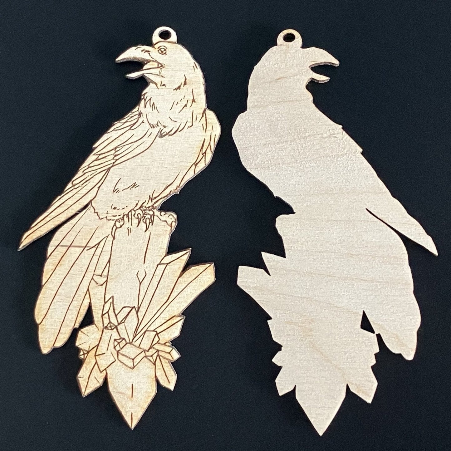 A photograph of the raven sitting on crystals ornament that shows the engraved front and the unengraved back. Raven with a Crystal Shaped Wooden Ornaments Art & Craft Kits Raven King Crafts