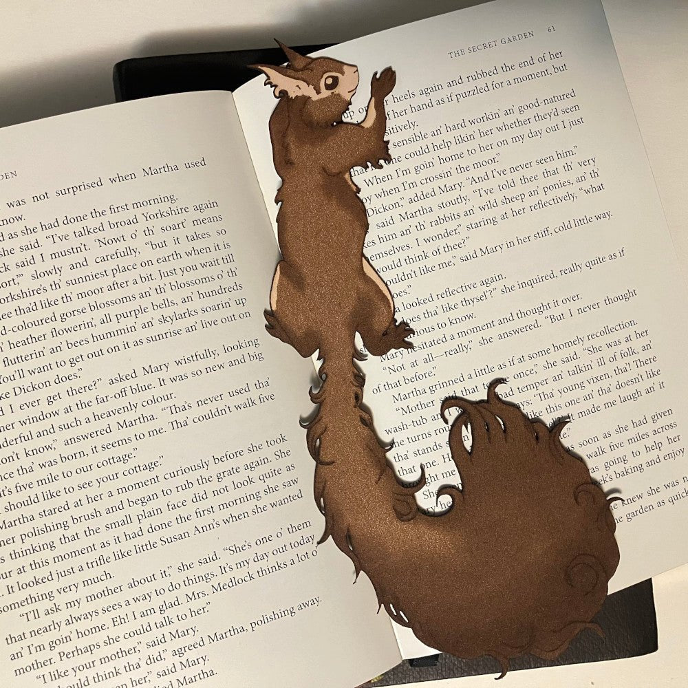 A photograph of a squirrel bookmark with a long bushy tail. Red Squirrel Bookmark - Leather Bookmarks Raven King Crafts