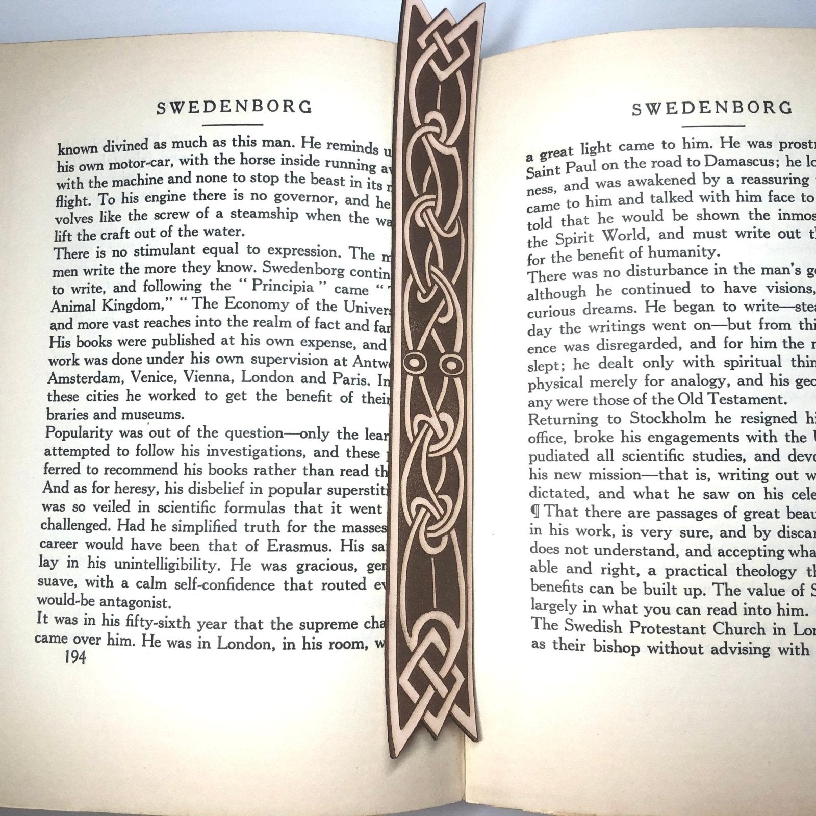 Another photograph of the ribbon shaped leather bookmark engraved with a Celtic knot design on it.