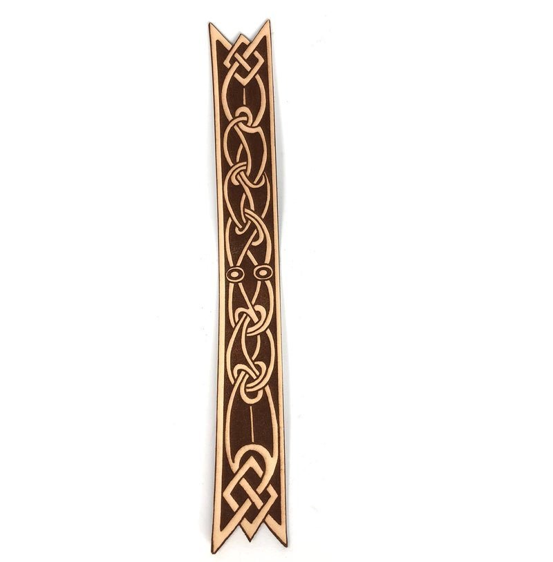 A leather bookmark cut in the shape of a ribbon with an Celtic knot design on it.