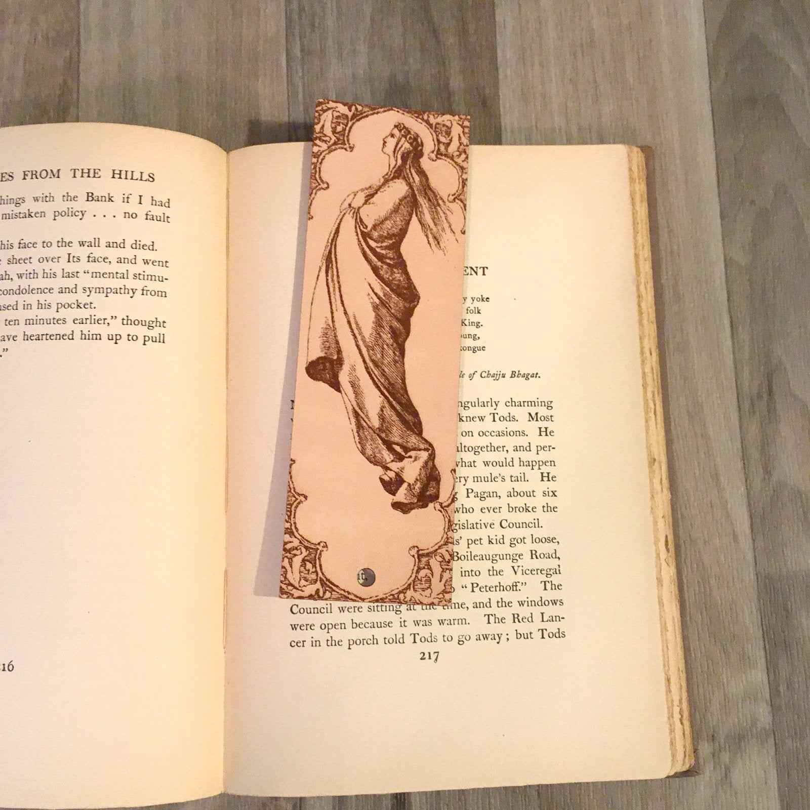 A leather bookmark with the antique art of a woman who appears to be floating up into the sky on it. Robed Woman Facing the Heavens Bookmark Bookmarks Raven King Crafts