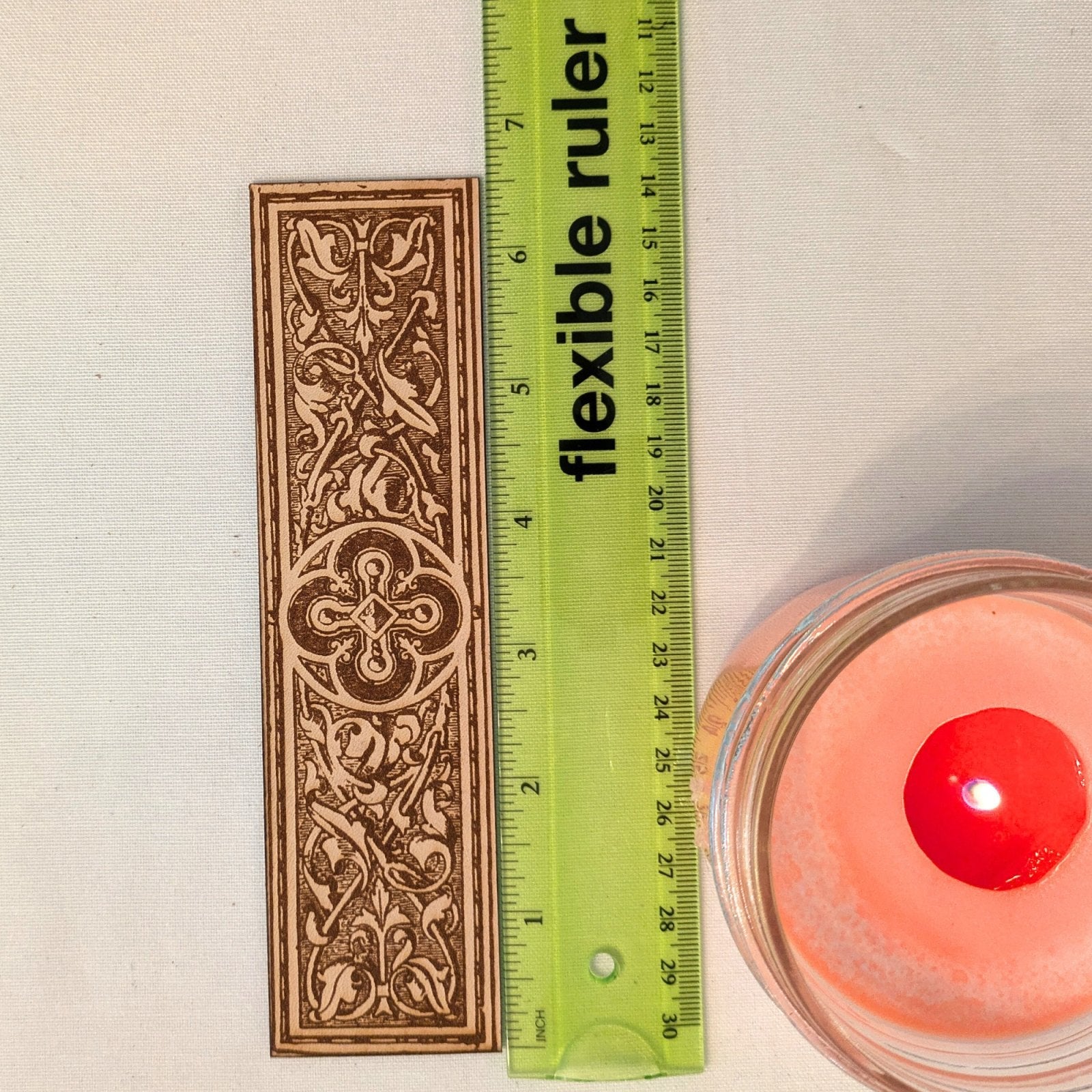A photograph of historical rounded cross medallion leather bookmark next to a ruler for scale. Rounded Cross Medallion Bookmark Bookmarks Raven King Crafts