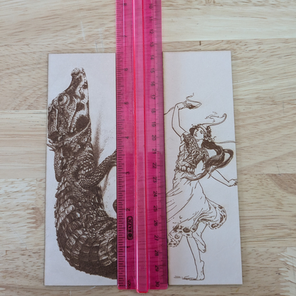 The woman dancing bookmark and dwarf crocodile bookmark next to a ruler for scale. 