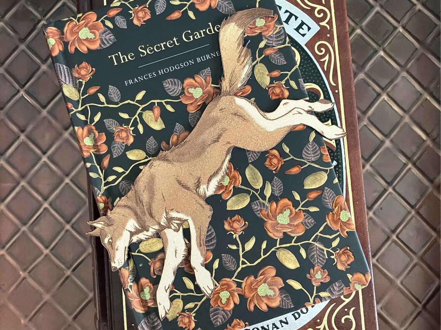 A leather bookmark shaped like a North American Wolf running.