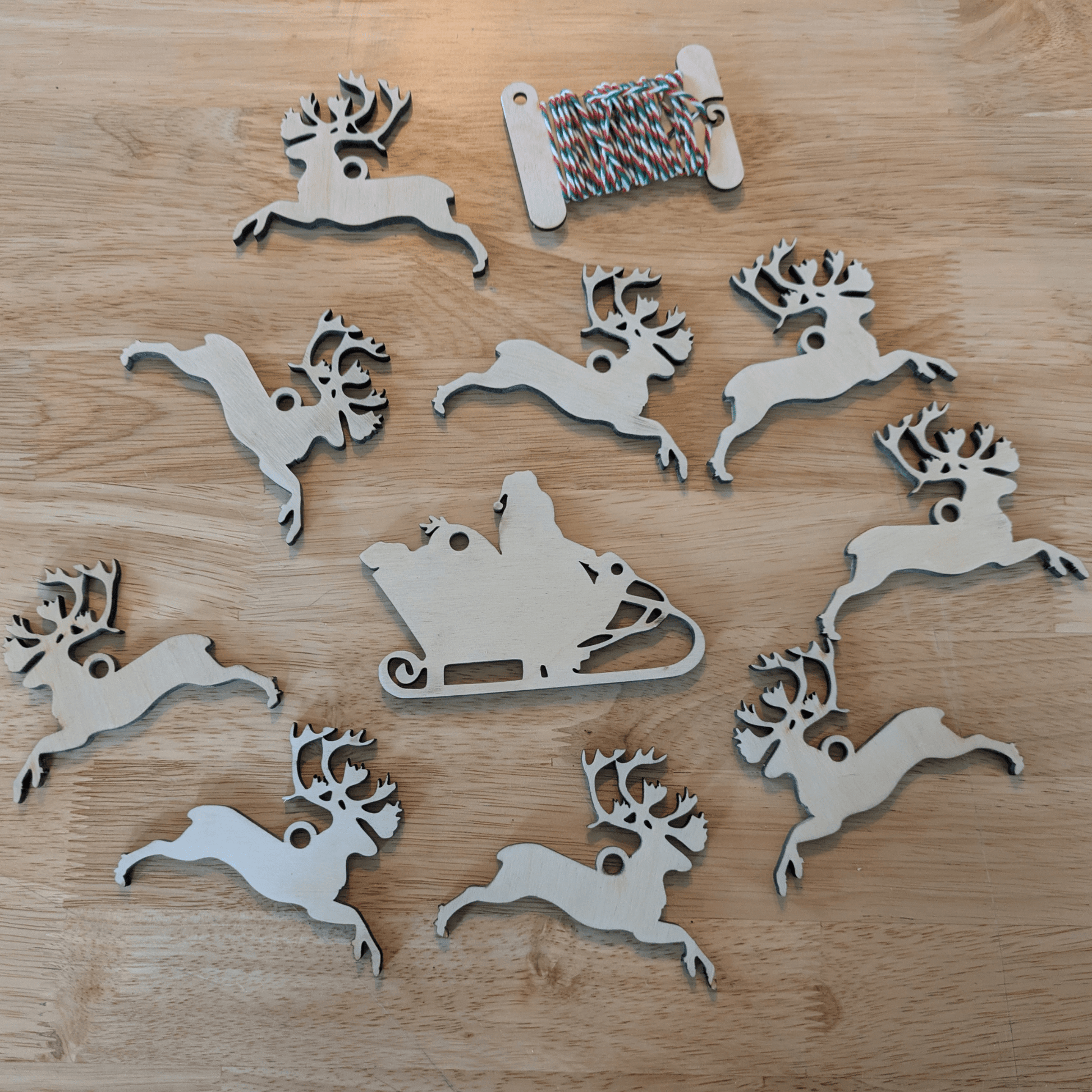 A photograph of the DIY Christmas ornament set with Santa and 9 reindeer. Santa and his reindeer ornament or garland blanks - 9 Deer, wooden Art & Craft Kits Raven King Crafts