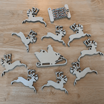 A photograph of the DIY Christmas ornament set with Santa and 9 reindeer. Santa and his reindeer ornament or garland blanks - 9 Deer, wooden Art & Craft Kits Raven King Crafts