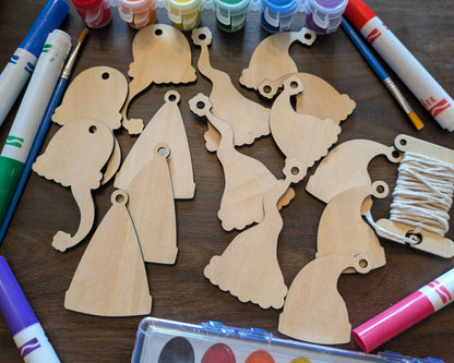A photograph of the wooden Santa hat Christmas ornament blanks. Around them are markers and paints you can select.