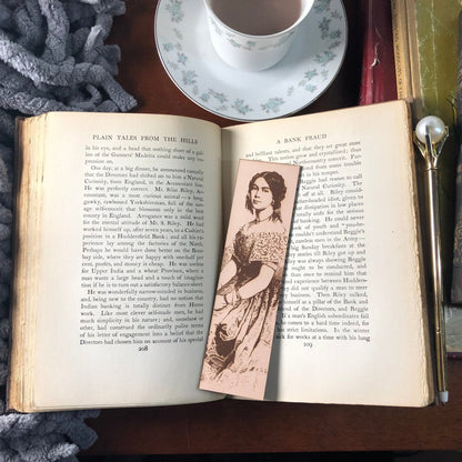 This photo is of the leather bookmark of a lady resting on an antique book.