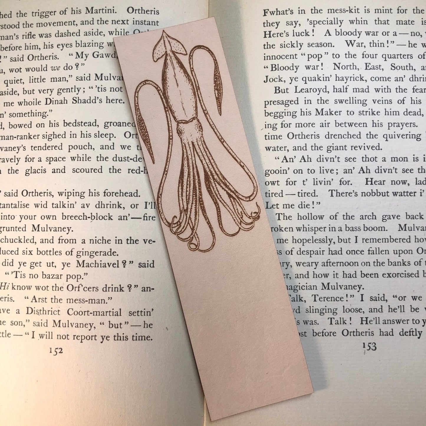 Leather squid bookmark resting on an antique book.