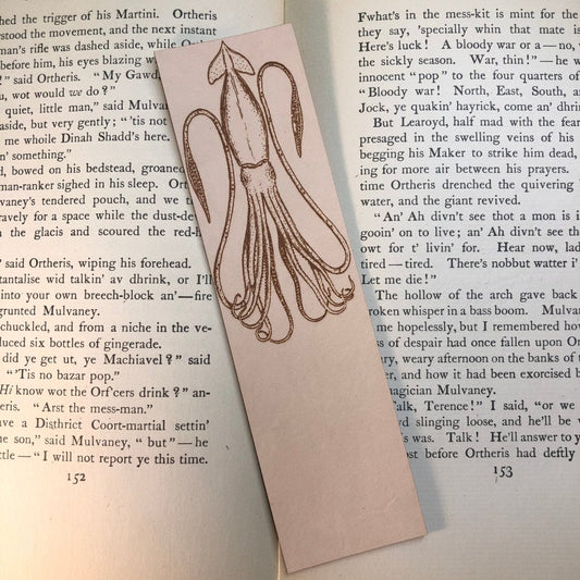 Leather squid bookmark resting on an antique book. Squid Bookmark Bookmarks Raven King Crafts