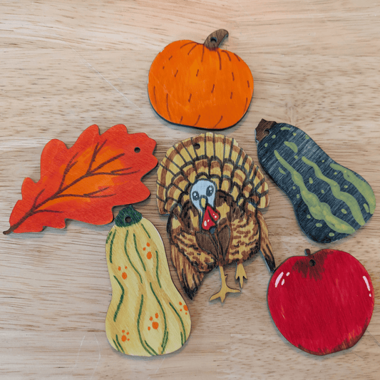 A photograph of some of the Thanksgiving ornaments colored, including a leaf, pumpkin, gourd, apple and turkey. Thanksgiving Ornament Kit Art & Craft Kits Raven King Crafts