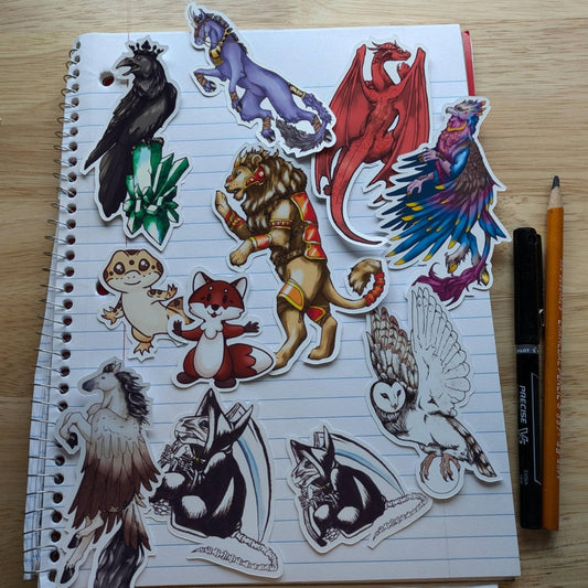 A photograph of the stickers offered by Raven King Crafts. Top left to bottom right: raven, unicorn, dragon, hippogriff, lion, gecko, fox, Pegasus, death rat, death rat and owl. Vinyl Sticker Packs - Pick Your Stickers! stickers Raven King Crafts Vinyl Sticker Packs - Pick Your Stickers! stickers Raven King Crafts
