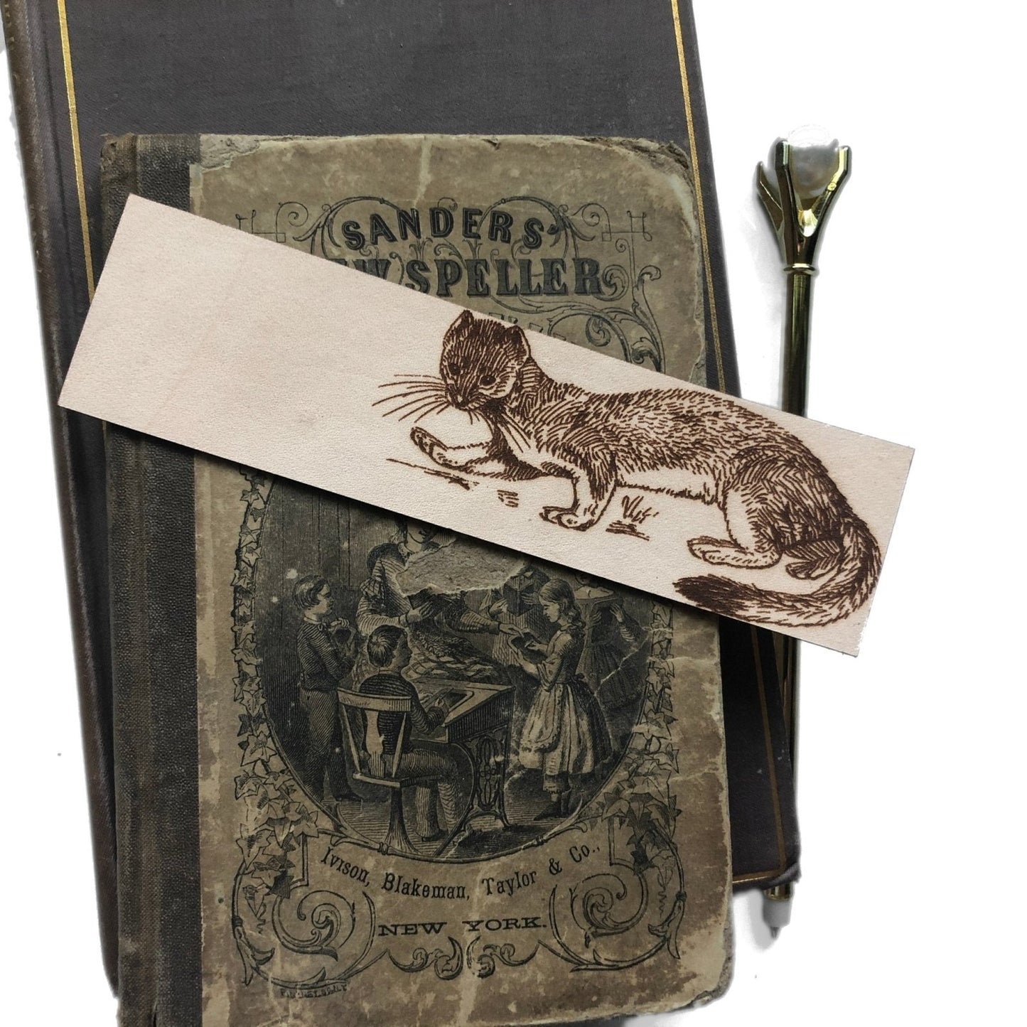 The leather weasel bookmark on top of some antique books.