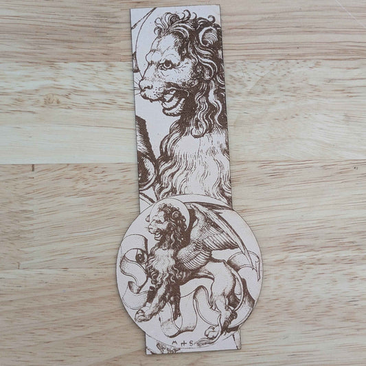 A photograph of a leather bookmark featuring the historical art of a winged lion beast.