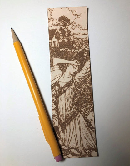 The woman in the water bookmark next to a pencil for scale. Woman in the Water Leather Bookmark Bookmarks Raven King Crafts