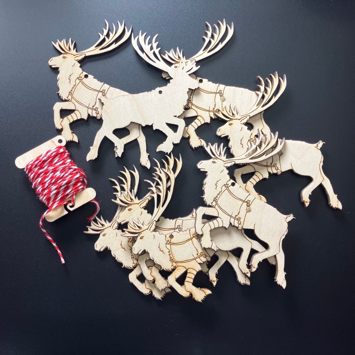 8 wooden reindeer ornaments and string. Each ornament is 1 sided.