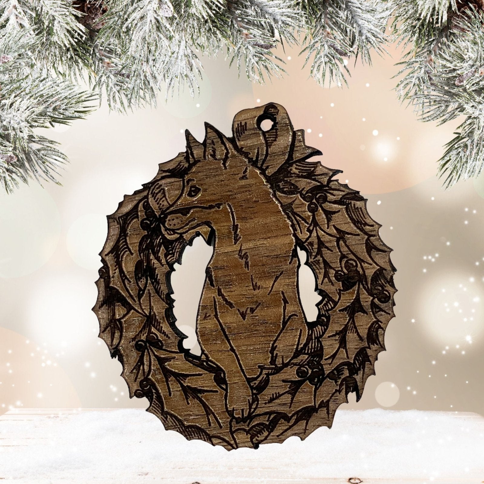 An example of the dark wood variety of the fox ornament. The fox is popping out of the wreath and the wood grain is visible.