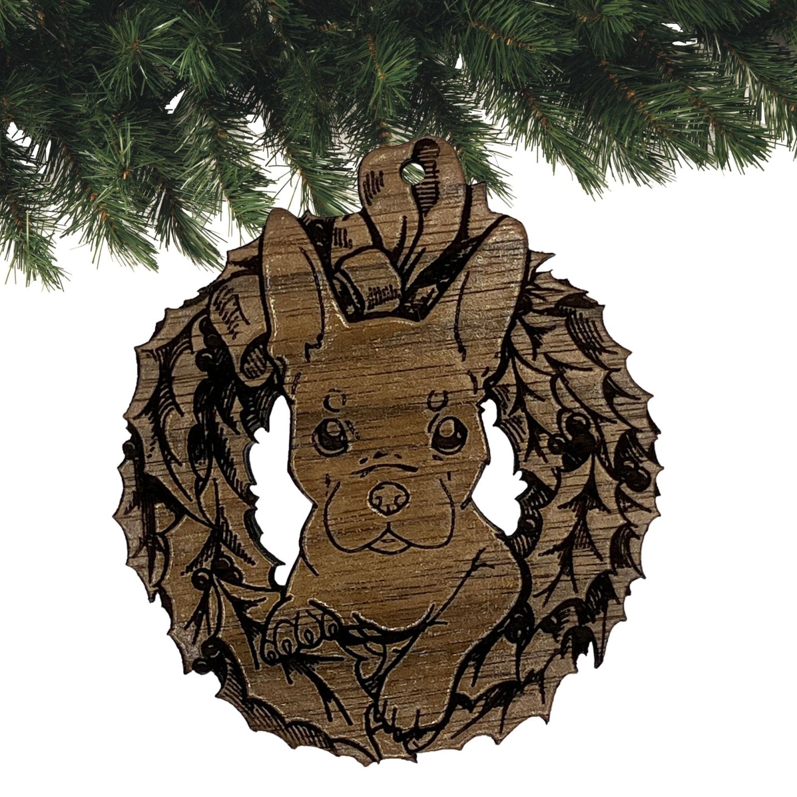 A photograph of the dark wood French Bulldog ornament. The ornament itself is cut in the shape of a wreath with the puppy's head popping through the middle. Wood French Bulldog Ornaments Ornament Raven King Crafts