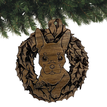 A photograph of the dark wood French Bulldog ornament. The ornament itself is cut in the shape of a wreath with the puppy's head popping through the middle. Wood French Bulldog Ornaments Ornament Raven King Crafts